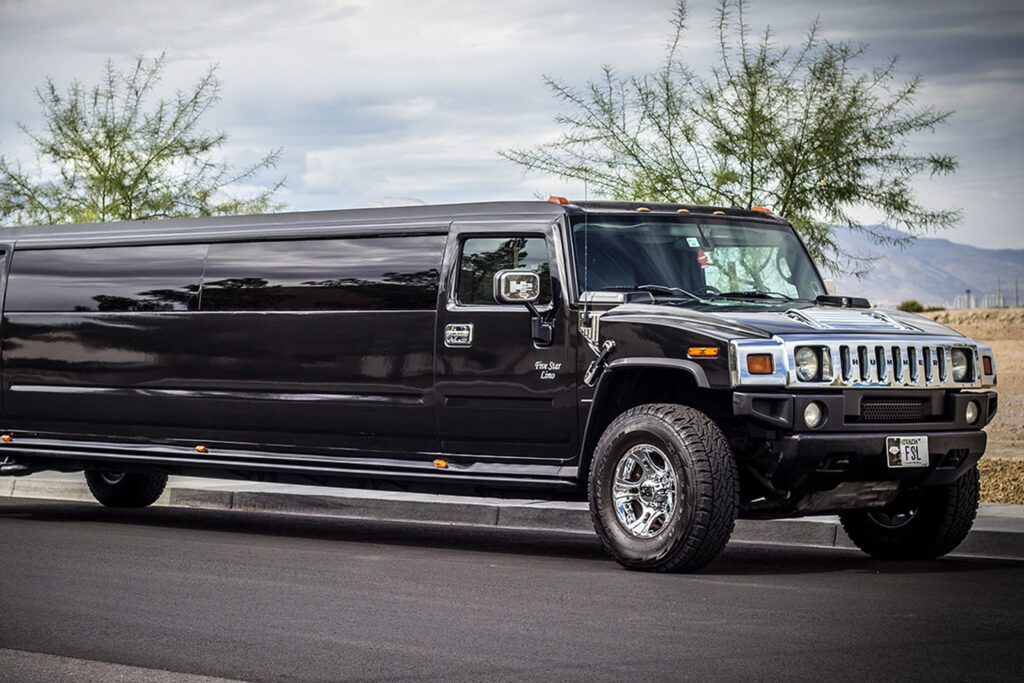 Black Hummer H2 Super Stretch limousine with tinted windows parked on the street