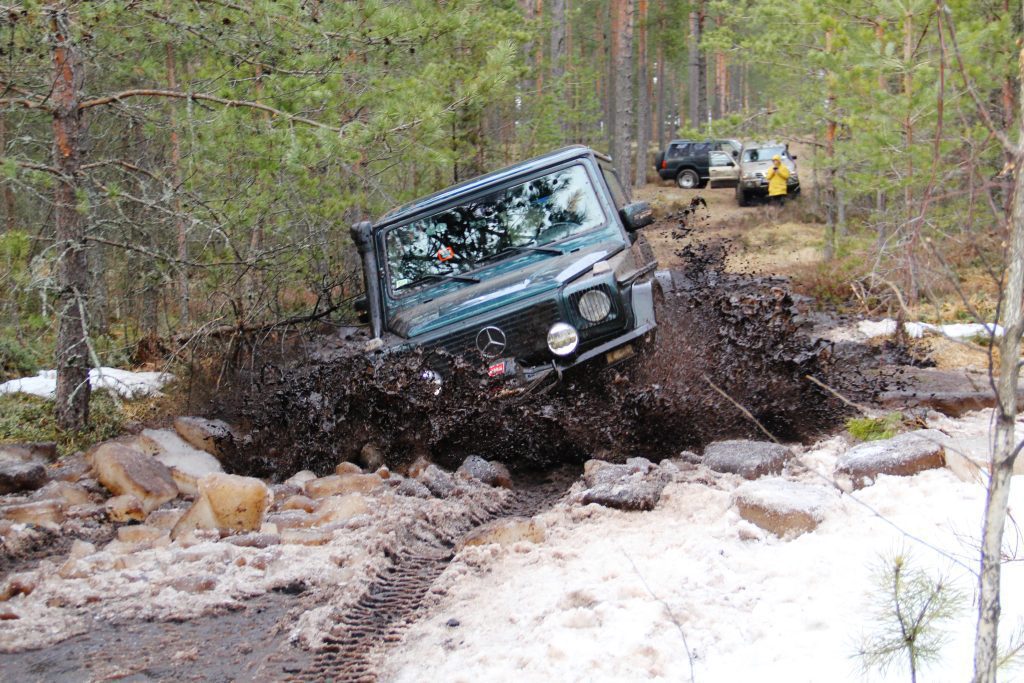 Mercedes G-Class driving through snow and mud in a forest
