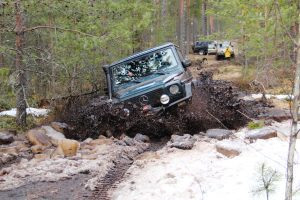 Mercedes G-Class driving through snow and mud in a forest