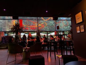 Neon-lit modern lounge bar with people enjoying dinner.