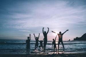 Friends jumping on the beach at sunset