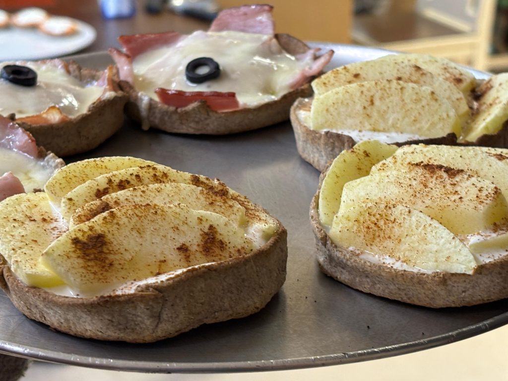 Traditional Latvian mini tarts with apple cinnamon and ham cheese toppings