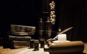 Riga Black Balsam bottles next to vintage books, garlic, and a candle