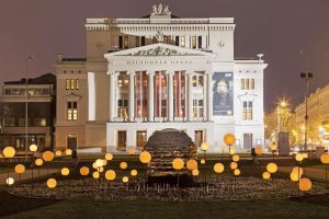 Front façade of the Latvian National Opera building at night.