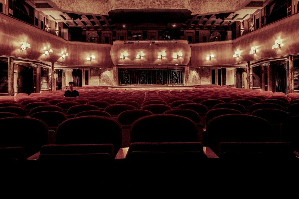 Empty vintage-style theater with red seats and soft lighting