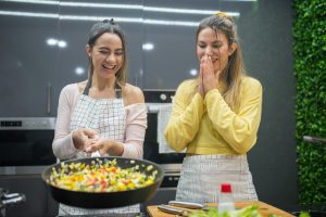 Two women cooking and laughing in a kitchen