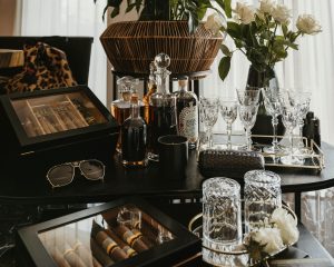 Elegant whiskey and cigar tasting setup with glasses and roses