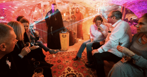 Guests sitting in a medieval cellar while a monk leads a degustation ceremony